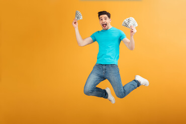 imagem de um homem feliz, pulando, segurando cédulas de dinheiro em um fundo colorido